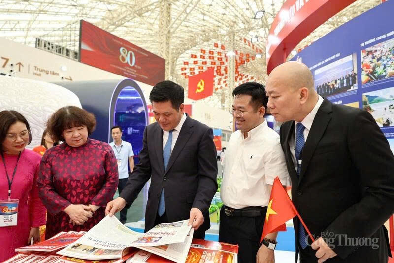 Minister of Industry and Trade Nguyen Hong Dien reads a special publication of the Industry and Trade Newspaper released on the occasion of the 80th anniversary of National Day, September 2.