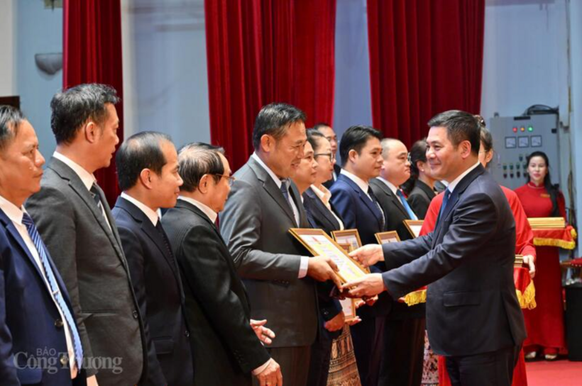 The Vietnamese Minister of Industry and Commerce presents certificates of merit to Lao organizations and individuals. Photo: Can Dung