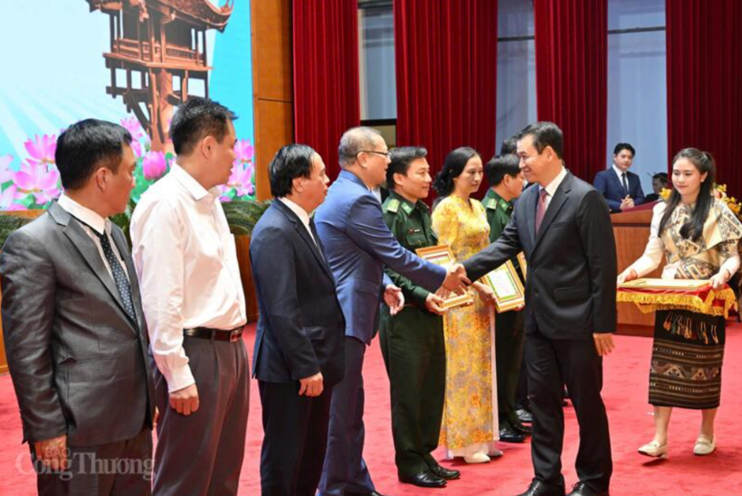 The Lao Minister of Industry and Commerce presents certificates of merit to Vietnamese organizations and individuals. Photo: Can Dung
