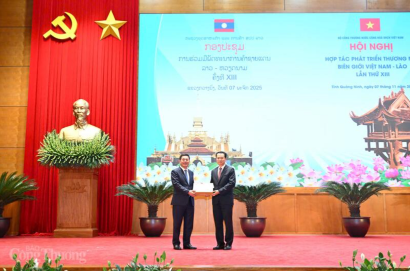 The Chairman of the Quang Ninh provincial People’s Committee presents souvenirs to the Vietnamese and Lao Ministers of Industry and Trade. Photo: Can Dung