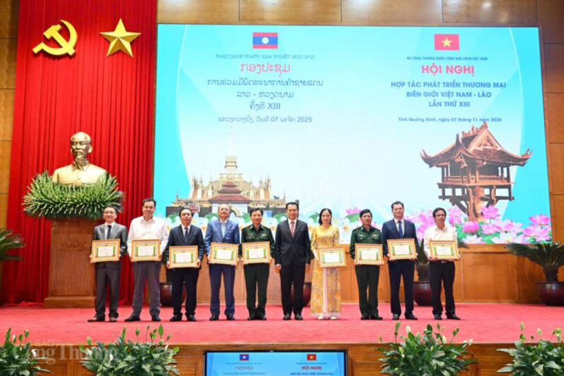 The Lao Minister of Industry and Commerce presents certificates of merit to Vietnamese organizations and individuals. Photo: Can Dung