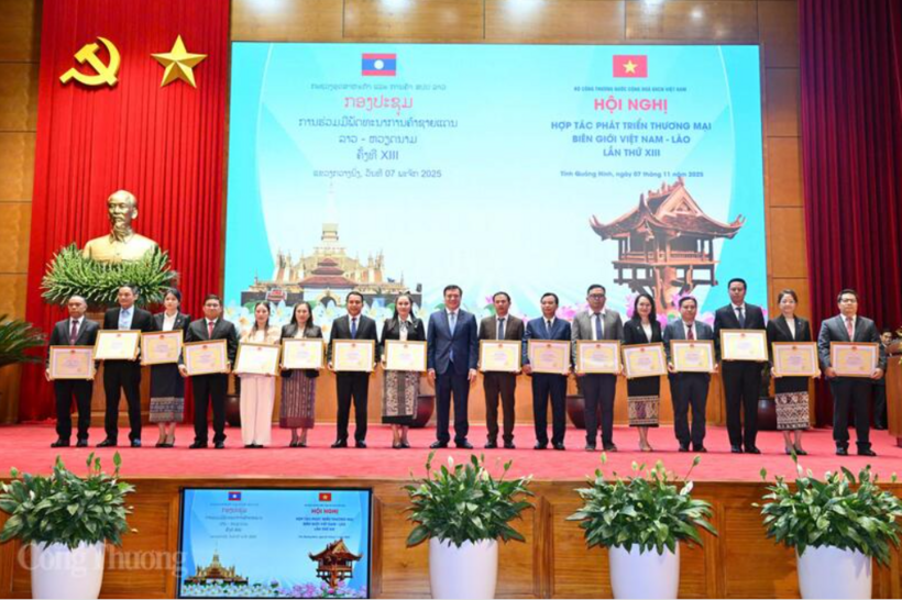 Vietnamese Deputy Minister of Industry and Trade Nguyen Sinh Nhat Tan presents certificates of merit to Lao organizations and individuals. Photo: Can Dung