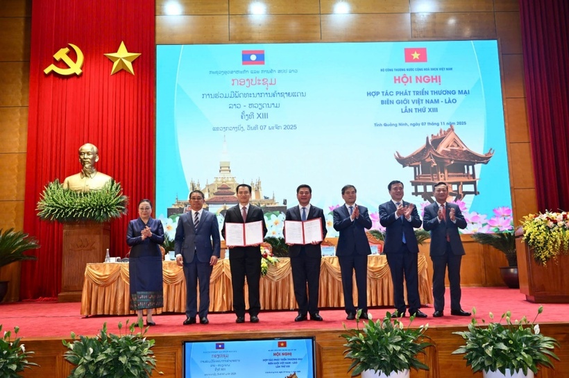 Vietnamese and Lao Ministers of Industry and Trade exchange the minutes of the 13th Vietnam-Laos Border Trade Cooperation Conference.