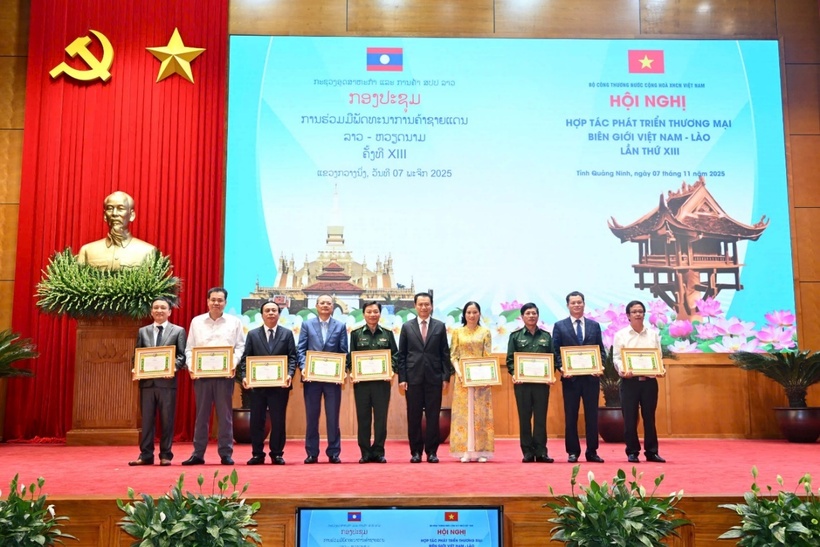 Lao Minister of Industry and Commerce presents Certificates of Merit to Vietnamese organizations and individuals.