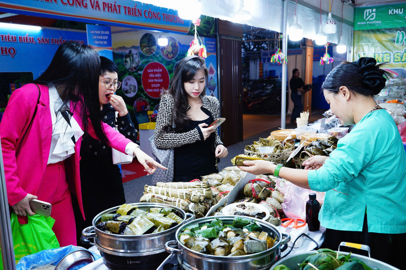 Visitors explore and purchase highland specialties at the Phu Tho cooperative’s booth, enjoying traditional flavors and experiencing local culinary culture.