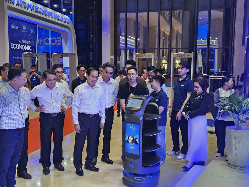 Deputy Prime Minister Bui Thanh Son discusses with young engineers the operation and demonstration of AI-powered robots at the forum. Photo: Minh Khue
