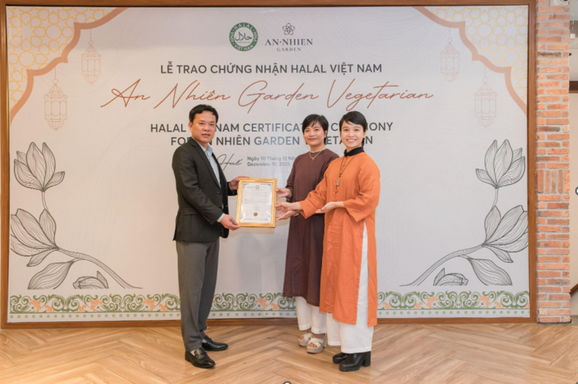 Tran Van Tan Cuong (left), director of Vietnam National Halal Co., Ltd., presents the Halal certificate to representatives of An Nhien Garden Vegetarian