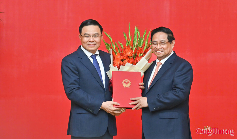 Prime Minister Pham Minh Chinh presents the decision appointing Comrade Le Manh Hung (left) as Acting Minister of Industry and Trade.