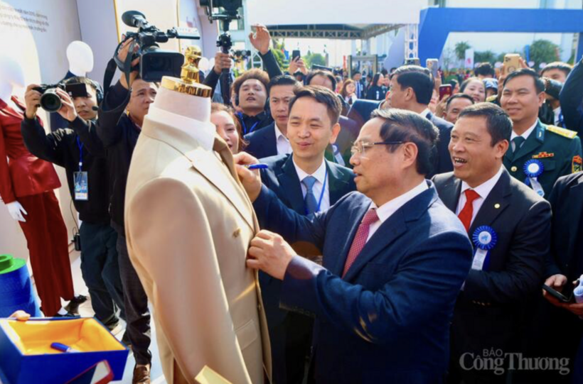 Prime Minister Pham Minh Chinh signs a commemorative note on a May 10 veston product.