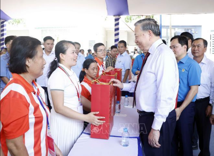 Party General Secretary and State President To Lam presents gifts to workers. Photo: VNA