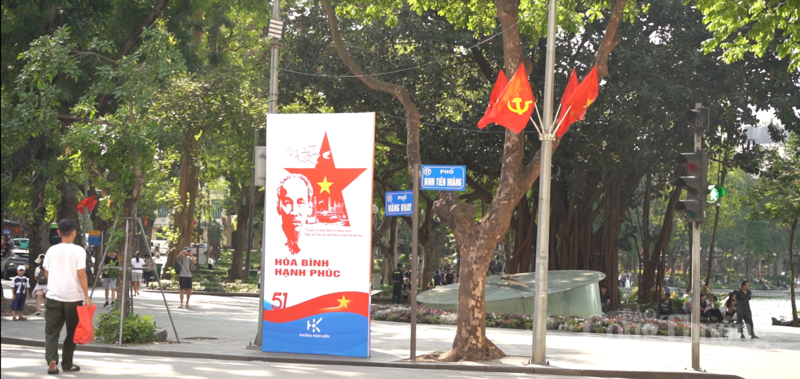 Banners and posters, together with the vivid red of the national flag, are prominently displayed around Hoan Kiem Lake, contributing to the spread of the April 30 commemorative atmosphere across central streets. Photo: Dieu Linh