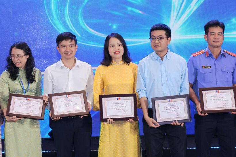 Journalist Nguyen Thi Thuy Linh, Deputy Editor-in-Chief of the Newspaper of Industry and Trade (in yellow), receives the “Outstanding and Impressive Exhibition Booth” award at the National Press Festival 2026.