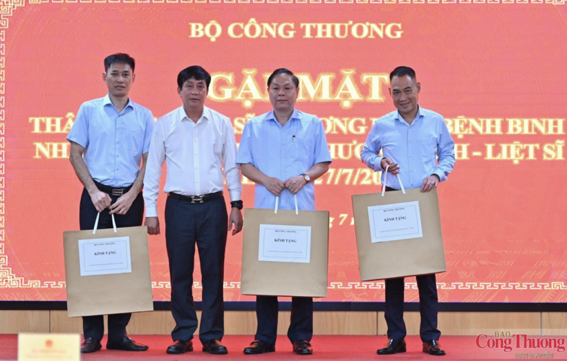 Phan Van Ban presents commemorative gifts to family members of martyrs, wounded soldiers and sick soldiers currently working at the Ministry of Industry and Trade. Photo: Nam Nguyen