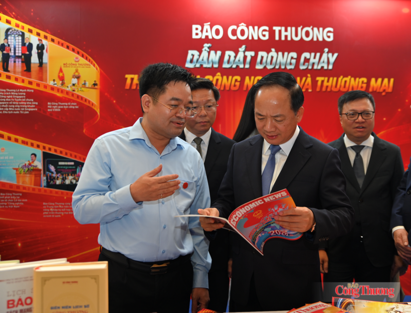 Editor-in-Chief of the Newspaper of Industry and Trade Nguyen Van Minh introduces the Viet Nam Economic News publication to Trinh Van Quyet, Politburo Member, Party Central Committee Secretary and Head of the Party Central Committee’s Commission for Publicity, together with leaders of the Viet Nam Journalists' Association, at the Newspaper of Industry and Trade exhibition booth at the 2026 National Press Festival. Photo: Nam Nguyen