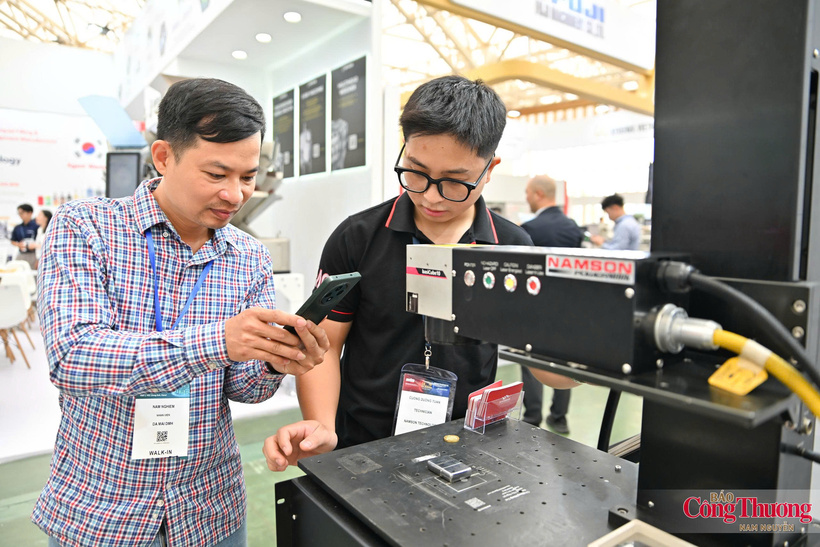 An attendee and a NAMSON Technology technician examine equipment at the exhibition.