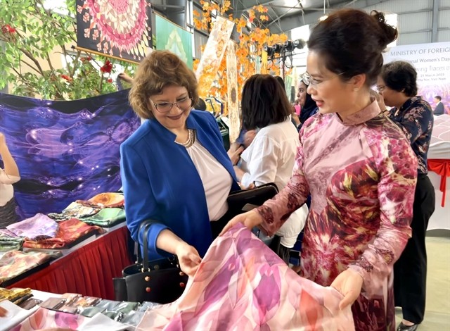 Founder of De Silk, Văn Hằng, presents a product to a guest at the event. Founder of De Silk, Văn Hằng, presents a product to a guest at the event.
