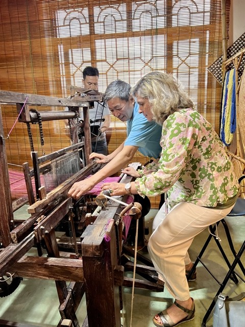 A guest learns how to weave silk. A guest learns how to weave silk.
