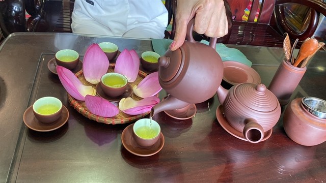 Thủy pours lotus tea into a traditional tea set. VNS Photo Lê Hương Thủy pours lotus tea into a traditional tea set. VNS Photo Lê Hương