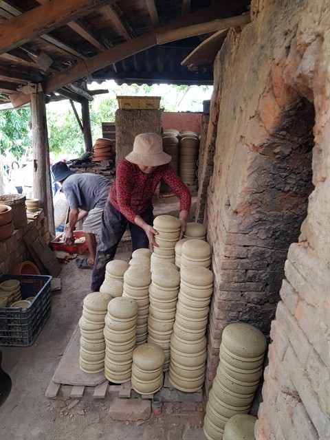 Potters place completely dried pots next to a kiln. Potters place completely dried pots next to a kiln.