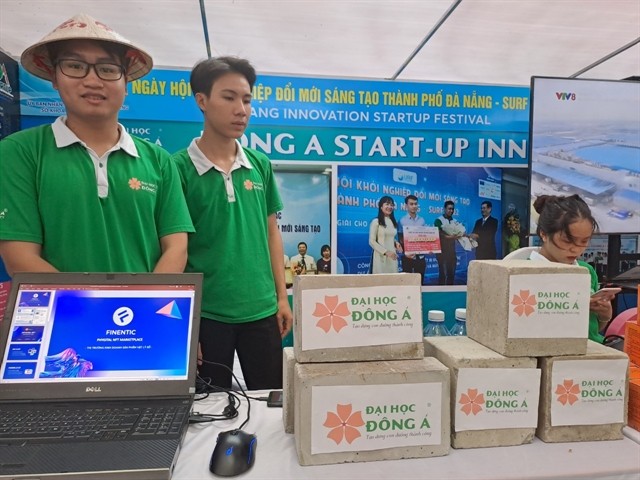 Students from Đà Nẵng's Đông Á University introduce unbaked bricks and concrete made from low carbon and environment-friendly material including recycle plastic bottles and sea sand. — VNS Photo Công Thành 