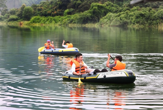 Tourists rowing rafts on Cấm Sơn Lake. Tourists rowing rafts on Cấm Sơn Lake.