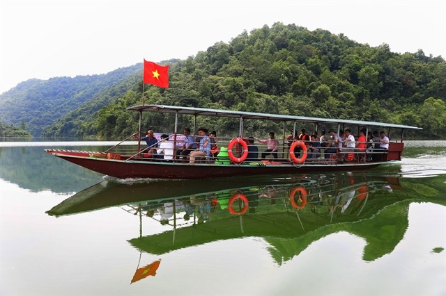 Tourists take a boat tour on Cấm Sơn Lake. Tourists take a boat tour on Cấm Sơn Lake.