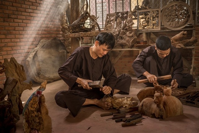 Two carpenters create wooden carvings at Kim Bồng carpentry village in Hội An. The trade contributes to community and tourism with its unique sculpture works. — Photo courtesy of Sơn Ca Two carpenters create wooden carvings at Kim Bồng carpentry village in Hội An. The trade contributes to community and tourism with its unique sculpture works. — Photo courtesy of Sơn Ca