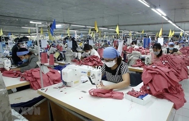 Workers produce garments for export. (Photo: VNA)
