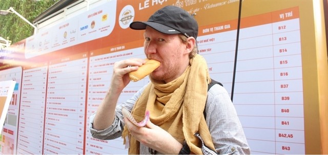 A foreigner is enjoying Vietnamese bread. — Photo vov.vn A foreigner is enjoying Vietnamese bread. — Photo vov.vn