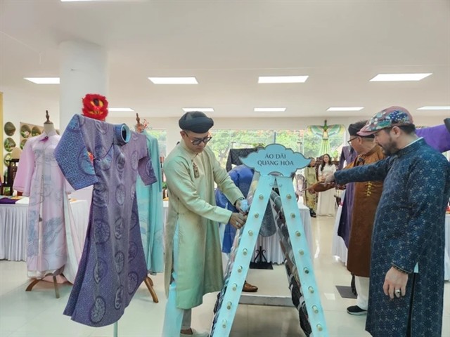 Tourists visit áo dài exhibition. VNA Photo