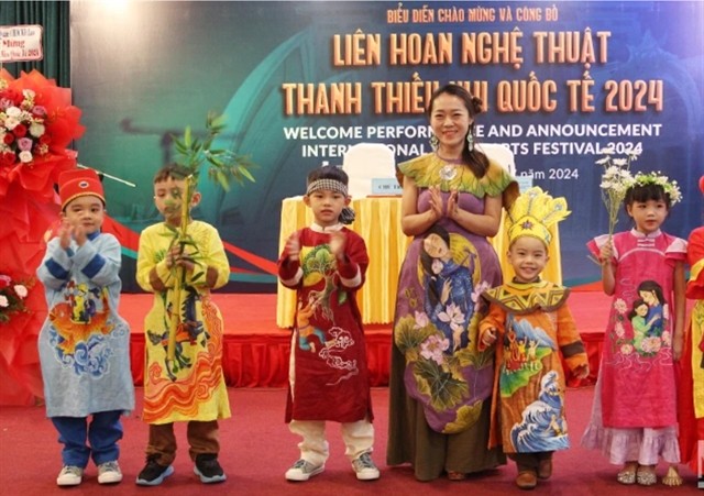 Vietnamese children in áo dài (traditional dress) perform at the festival's announcement event on Friday in Đà Nẵng. Photo nhandan.vn