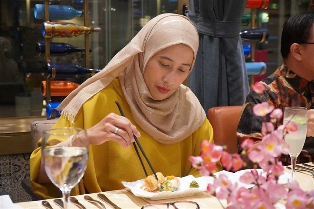 An Indonesian guest enjoys Vietnamese food at the event. VNA/VNS Photo Đỗ Quyên 