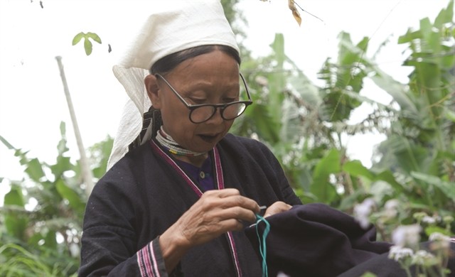 A Dao Tiền woman embroiders patterns on her scarf. — VNS Photo Lê Việt Dũng A Dao Tiền woman embroiders patterns on her scarf. — VNS Photo Lê Việt Dũng