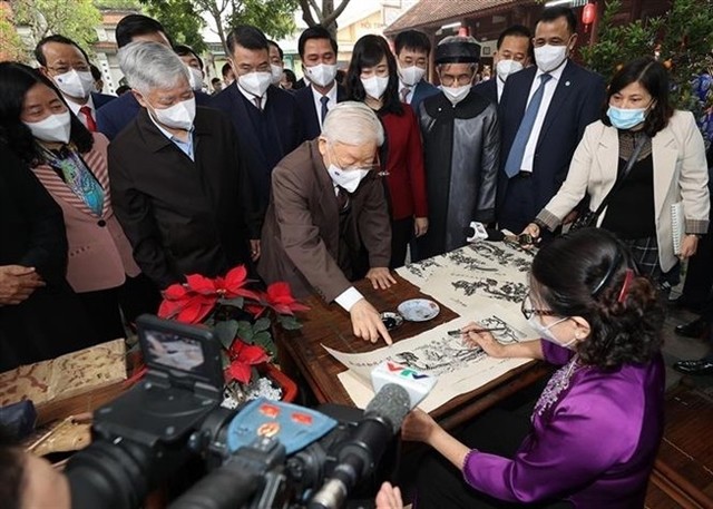 General Secretary Nguyễn Phú Trọng learns about the Đông Hồ traditional woodblock-printing paintings at the Đô Temple historical-cultural relic in Từ Sơn City on January 24, 2022. — VNA/VNS Photo Trí Dũng