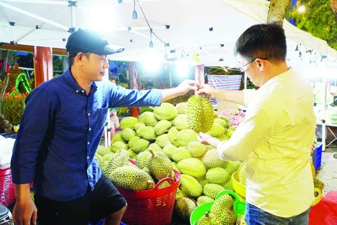 A farmer from the Mekong Delta province of Tien Giang introduces his durian to a client (Photo: sggp.org.vn)