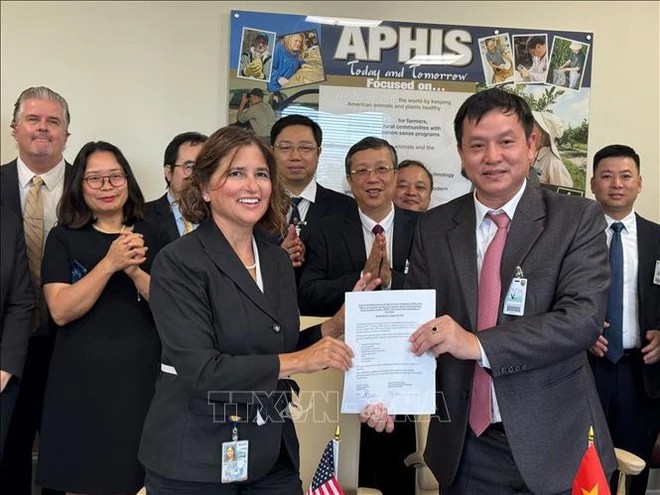 Deputy Director of APHIS Plant Protection Quarantine, Jessica Mahalingappa, and Director of the Plant Protection Department, Huynh Tan Dat, exchange Framework Agreement on Training and Capacity Building in Plant Quarantine (Photo: VNA(