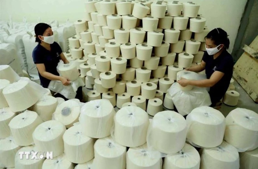 Employees work at a polyester yarn factory. (Photo: VNA)