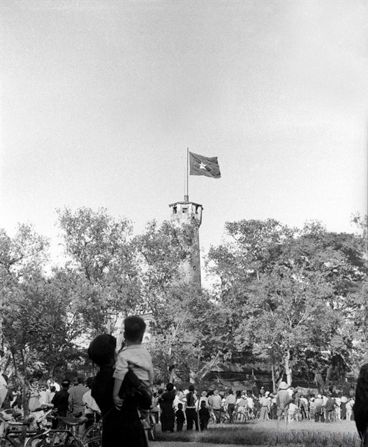 Hà Nội residents look up at the Vietnamese gold-star flag flying on the Flag Tower, a powerful symbol of their newly won freedom on October 10, 1954. — VNA/VNS Photo