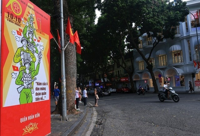 A poster at the Bà Triệu-Hàng Khay Intersection which reads 'The five city entrances celebrate the arrival of the troops.' A poster at the Bà Triệu-Hàng Khay Intersection which reads 'The five city entrances celebrate the arrival of the troops.'