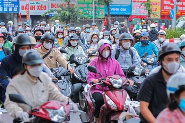 Hanoians wear warm clothes when going out on Monday morning.— VNA/VNS Photo Hoàng Hiếu