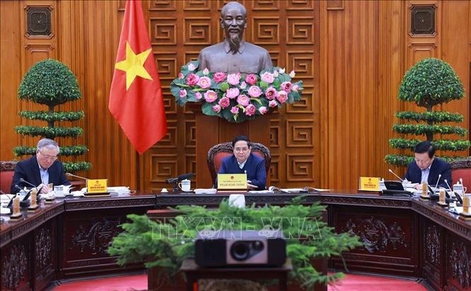 Prime Minister Pham Minh Chinh (C) chairs the fourth meeting of the government steering committee to review the implementation of Resolution No. 18-NQ/TW on December 17. (Photo: VNA)