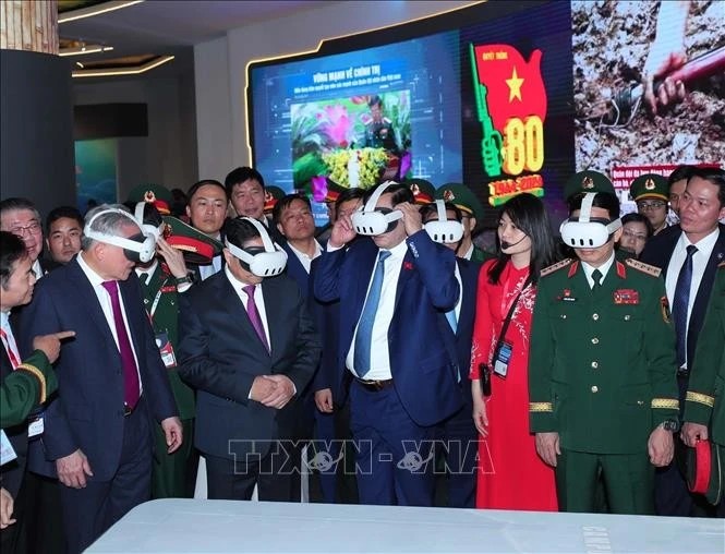 Prime Minister Pham Minh Chinh (second from left) visits the defence product exhibition area of ​​Viettel on December 19. (Photo: VNA)