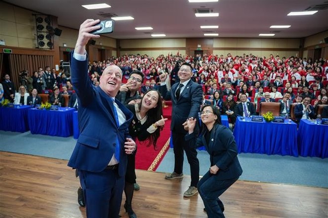 New Zealand Prime Minister Christopher Luxon takes a photo with FTU lecturers and students at the event. (Photo: VNA)