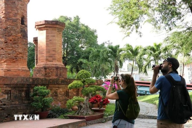 Two Russian tourists take photos at the Ponagar Tower relic site in Khanh Hoa province. (Photo: VNA)