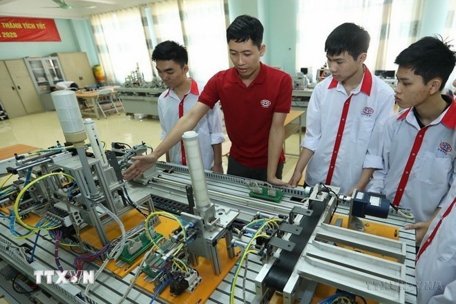 A teacher introduces an automation model to students of the Industrial Electronics Class K13, Hanoi High-Tech Vocational College. (Photo: VNA)