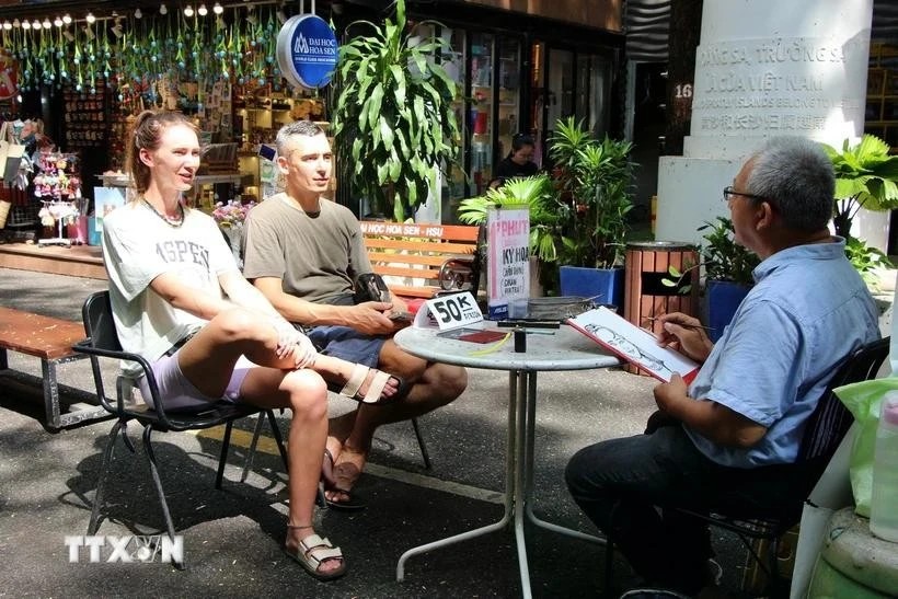 Foreign tourists enjoy a painting service on Nguyen Van Binh book street in Ho Chi Minh City. (Photo: VNA) Foreign tourists enjoy a painting service on Nguyen Van Binh book street in Ho Chi Minh City. (Photo: VNA)