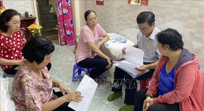 The inspection team on the implementation of the sustainable poverty reduction programme for the 2021-2025 period reviews the list of poor and near-poor households in HCM City’s District 5 (Photo: VNA)