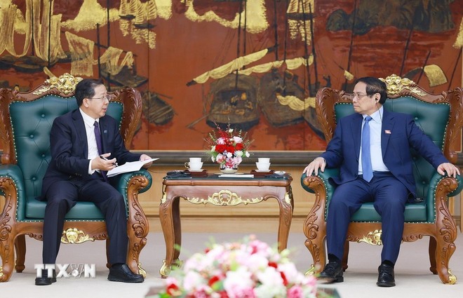 Prime Minister Pham Minh Chinh (R) hosts a reception for Chairman of China Huadian Engineering Co., Ltd Peng Gangping, Ha Noi, May 14, 2025. Photo: VNA